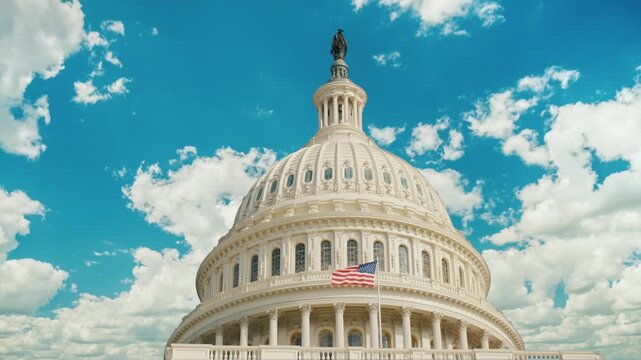 Us capitol building dome in washington dc with clouds moving across blue sky.