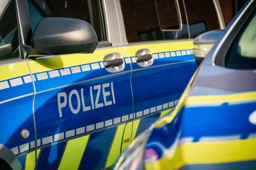 Deutsche Polizeifahrzeuge in blau-gelber Warnbeklebung mit gut sichtbarem Schriftzug „Polizei“. © mpix-foto