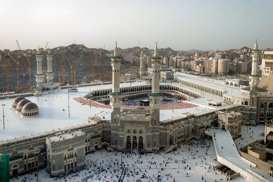 Aerial view of Masjid al-Haram with its minarets, the Kaaba in the courtyard, expansive white marble prayer areas, and construction cranes in Makkah, Makkah Province, Saudi Arabia.