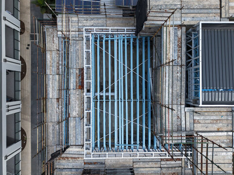 Aerial view of a construction site featuring intricate scaffolding and exposed steel beams on an industrial building in Melbourne, VIC, Australia.