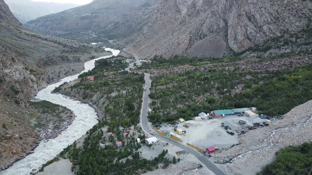 Aerial View of Serene Himalayan Valley with Winding Road, River, and Colorful Buildings at Dusk