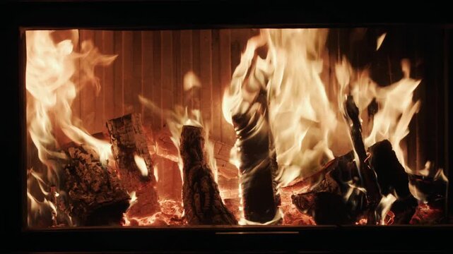 Cinematic wood burning fireplace with glowing embers and vibrant orange flames in slow motion.
