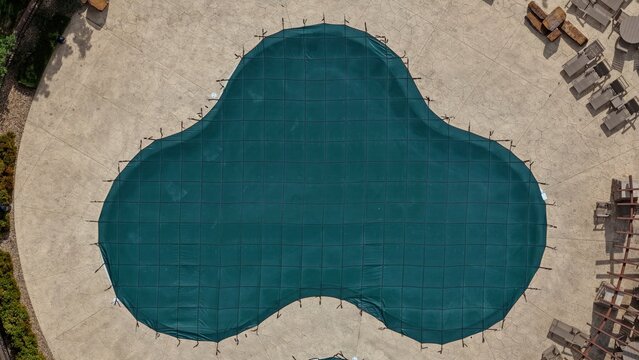 Aerial view of a swimming pool covered with a green safety net surrounded by a stone patio, Golden, Colorado, United States.
