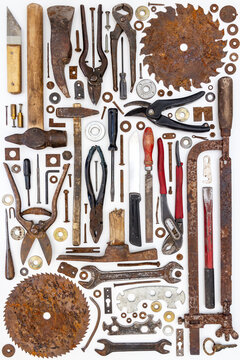 Flat lay of old hand tools on white background. Large collection of various rusty tools and bits arranged on white.