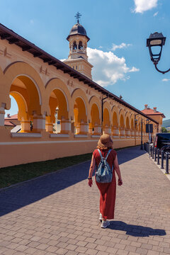 Woman walking beside arcaded gallery of Coronation Cathedral in Alba Iulia Romania