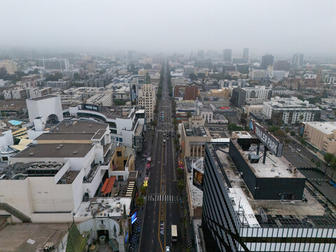 Aerial view of the Hollywood Walk of Fame featuring the iconic street lined with historic buildings and urban infrastructure under a cloudy sky in Los Angeles, California, United States.