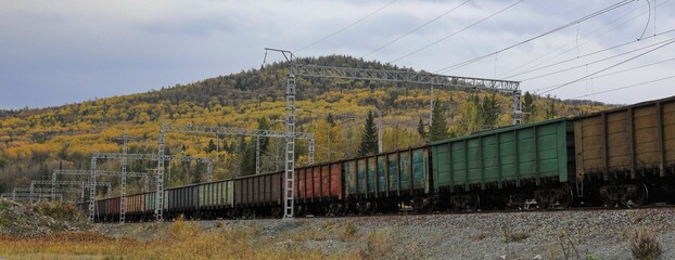 A freight train transports coal in wagons by rail. © Artyom