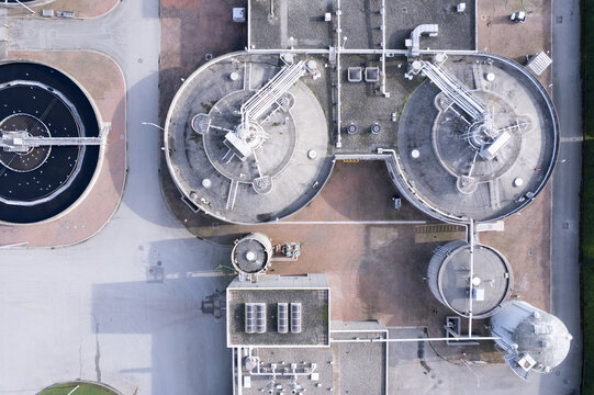 Aerial view of the Waste Water Treatment facility featuring circular sedimentation tanks, industrial piping, and concrete infrastructure in Richmond, British Columbia, Canada.