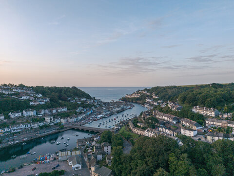 Aerial view of the coastal town of Looe with its harbor, boats, and historic buildings nestled along the river in Looe, Cornwall, United Kingdom.