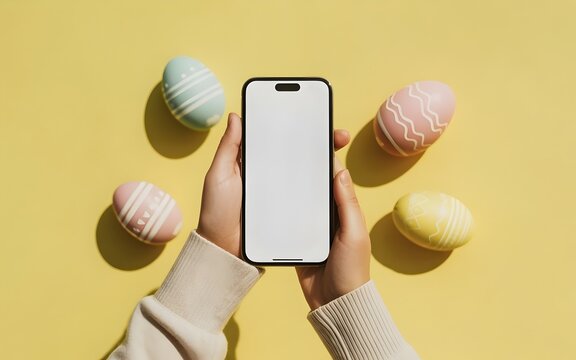Person holding a smartphone with an empty white screen surrounded by decorated Easter eggs