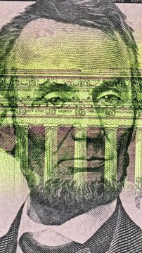 Lincoln Portrait Shifts Beneath Green Banknote Security Scan. Five dollar bill shows Lincoln portrait beneath smooth green security light scan. Printed face shifts while bands of light reveal banknote