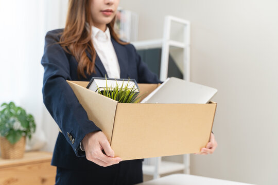 Office worker packing stuff to leave office after resign from job.