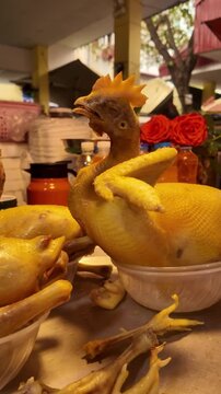 Close up view of cooked whole boiled chickens displayed at a street food market stall during day in Hanoi, Vietnam