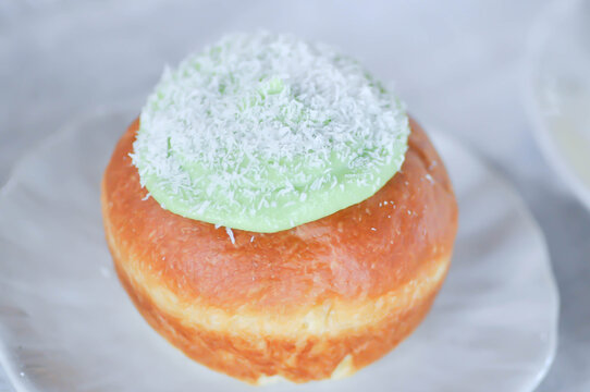 brioche donut or  doughnut or bun with green tea dressing or pandan custard and Coconut flakes topping