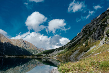 Mountain landscape with a pond and clouds. Czarny Staw pod Rysami in the High Tatras. © Tomasz