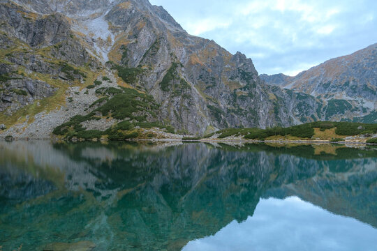 A mountain pond with reflecting peaks. The Black Pond below Rysy in the Tatra Mountains. Czarny Staw pod Rysami. Tatry Wysokie.