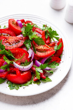 Sliced tomato salad with crisp red onion. Natural organic vegan food for healthy diet. Fresh summer harvest meal showcasing wellness lifestyle and delicious local farm market agriculture.