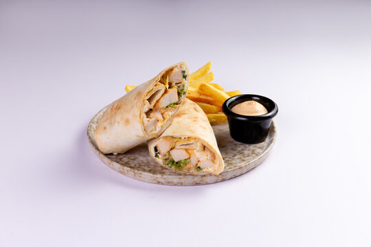 Chicken wrap halves with french fries and dipping sauce food