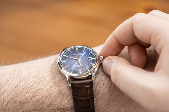 Poznan, Poland - January 17, 2026: Seiko Presage watch adjusted by a person with a brown leather strap, representing luxury, precision, and classic style in professional settings