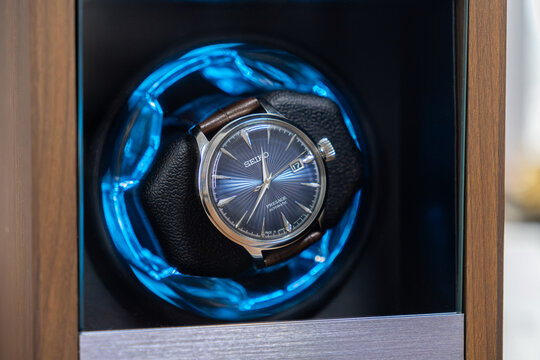Poznan, Poland - January 17, 2026: Seiko automatic watch rotating in a wood case with glowing blue led lights to ensure precision, showcasing luxury craftsmanship and elegance
