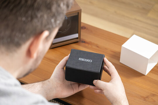 Poznan, Poland - January 17, 2026: Seiko watch box held by a man at a wooden table, emphasizing the premium unboxing experience and quality craftsmanship of a luxury timepiece brand