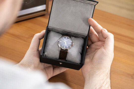 Poznan, Poland - January 17, 2026: Seiko watch inside a gift box held by a man to show premium quality and luxury style for a classic timepiece on a warm wooden surface in a room