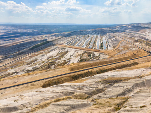 Aerial view of the Hambach open pit mine with lignite extraction and solar photovoltaic modules, showing the transition to renewable energy in Elsdorf, North Rhine-Westphalia, Germany.