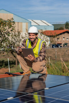 vertical Solar engineer checking installation with tablet on rooftop