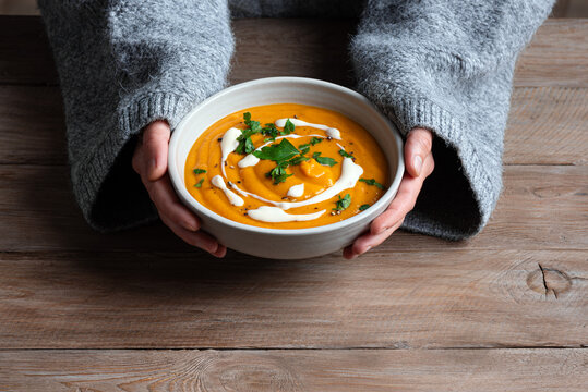 Bowl of red lentil soup in woman hands