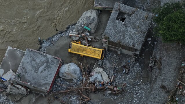 Aerial view of flood damage showing a stranded yellow bus and debris near the river in Betrawoti Bazaar, Bagmati Province, Nepal.