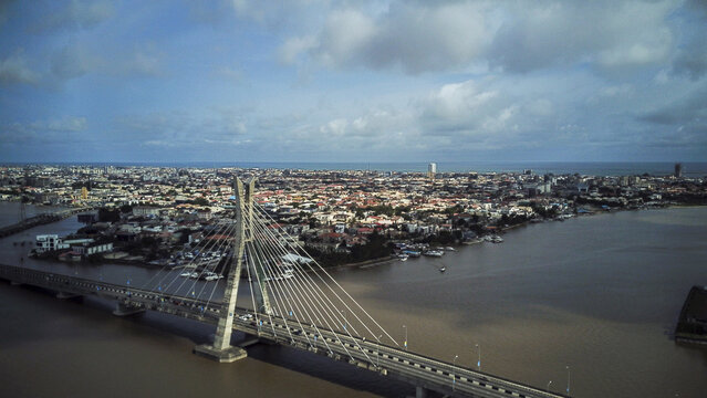 Aerial view of the Lekki-Ikoyi Link Bridge spanning the lagoon with the dense urban skyline of Victoria Island and Lagos in the background, Lagos, Lagos, Nigeria.