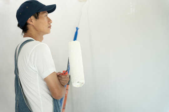painter man prepare brush for products to restore and paint the wall, indoor the building site of a house, wall during painting, renovation, painting, contractor, Architect, construction worker