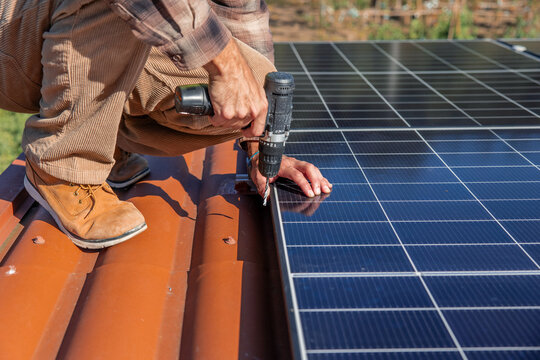 Solar engineer installing photovoltaic panel on rooftop