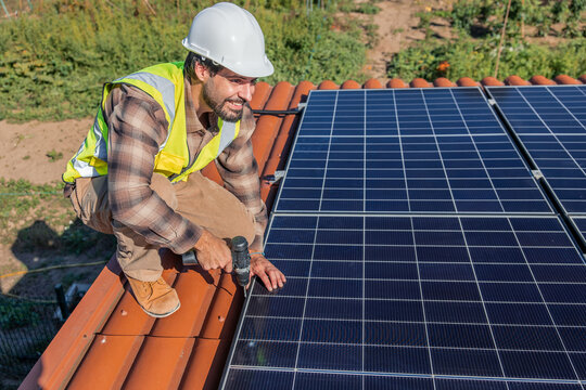 Solar engineer installing photovoltaic panels on building roof