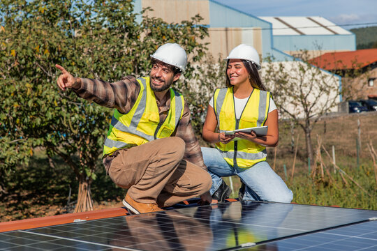 Multicultural solar engineers installing renewable energy panels