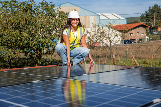 Female solar engineer installing photovoltaic panels for green energy