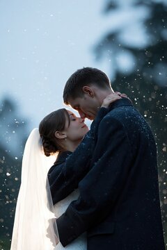 Bride and groom sharing a quiet kiss in falling snow