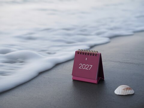 Calendar washed ashore on a sandy beach with ocean waves in the background