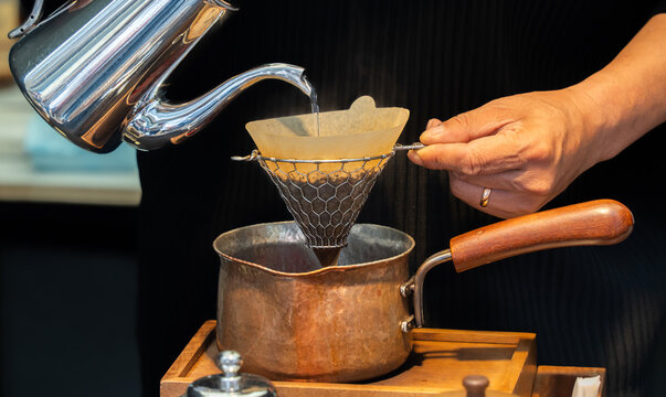Pour-over coffee brewing with paper filter and copper pot