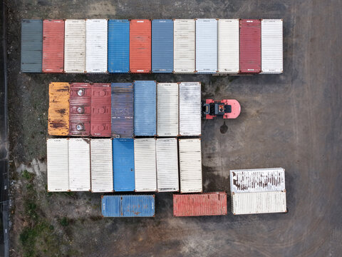 Melbourne, Australia - 25 September 2026: Aerial view of colorful shipping containers arranged in a storage yard with a forklift operating nearby.