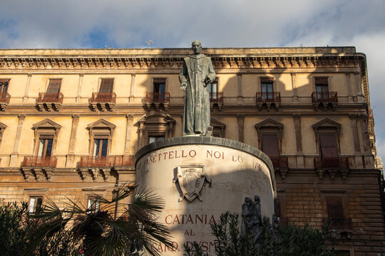 Bronze statue of Blessed Giuseppe Dusmet standing in front of a historic building in Catania Italy