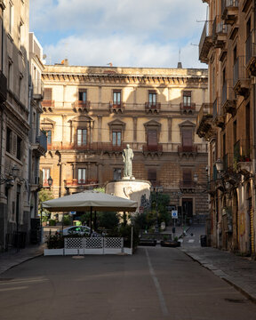 Bronze statue of Blessed Giuseppe Dusmet standing in front of a historic building in Catania Italy