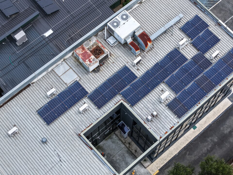 Melbourne, Australia - 25 September 2026: Aerial view of a rooftop featuring solar panels and HVAC units on an industrial building.
