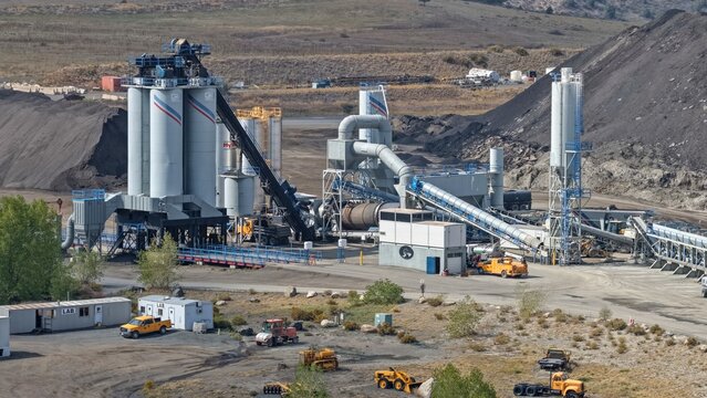 Golden, United States - 25 September 2026: Aerial view of an industrial concrete batch plant with tall silos, conveyor belts, and heavy machinery in a rural setting.