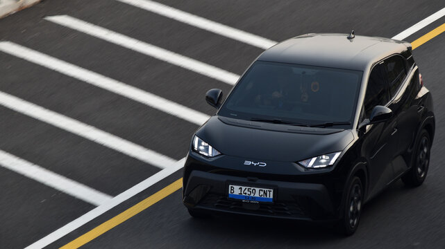 A black BYD Atto 1 EV driven on the toll road