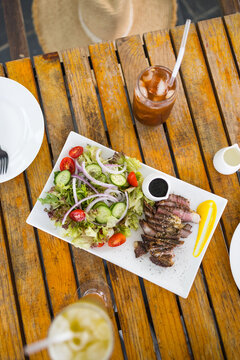 Top view of grilled steak and fresh garden salad served on plate