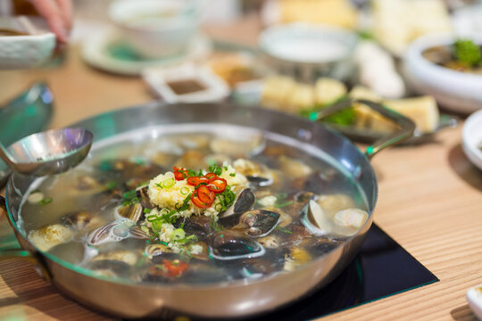 Hot pot soup with seafood and vegetables on dining table