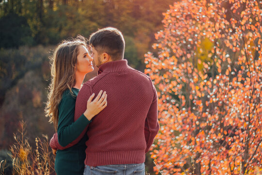 Couple embracing outdoors during autumn season.