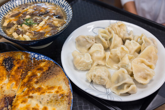 Boiled Chinese dumplings served with hot soup bowl