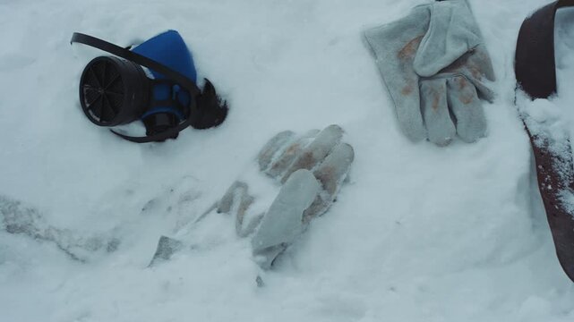 Frozen gear and cautious rescuer peeking over drift to inspect gloves, mask, and strap half buried in snow search technician reaches for beacon and recorder, scanning horizon, tension mixed with hope